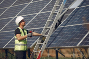 man in a white helmet near a solar panel